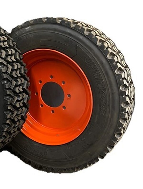 Snow tire mounted on a red 8-lug skid steer wheel